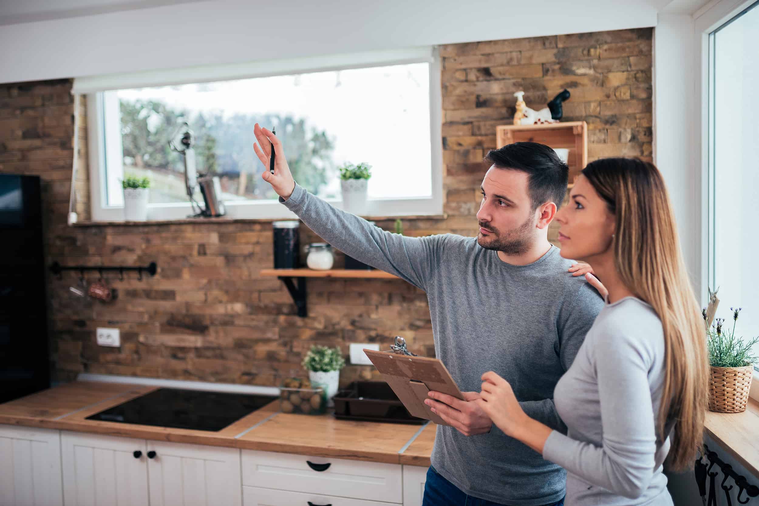 a man and women in a kitchen looking at something