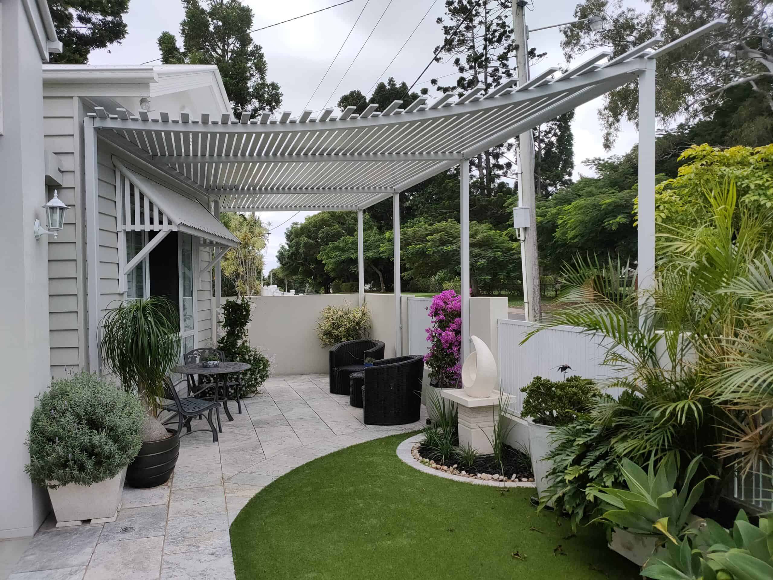 A pergola sits of the outdoor area of a suburban home