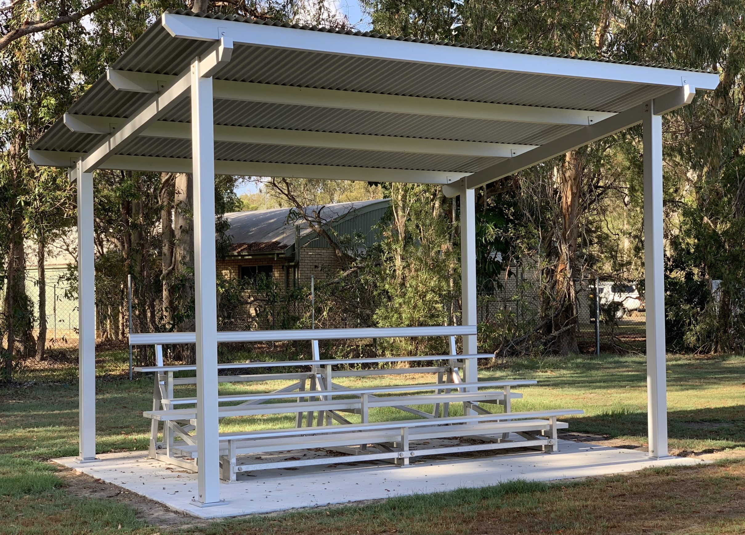 a tiered seating area with a roof shelter in an australian park